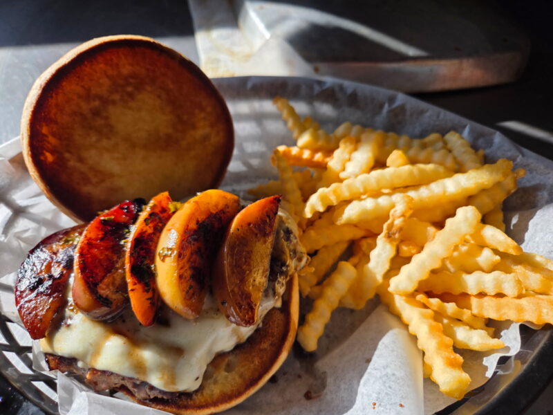 best burger in the bluffs Bar & Grill burger with onion rings and fries